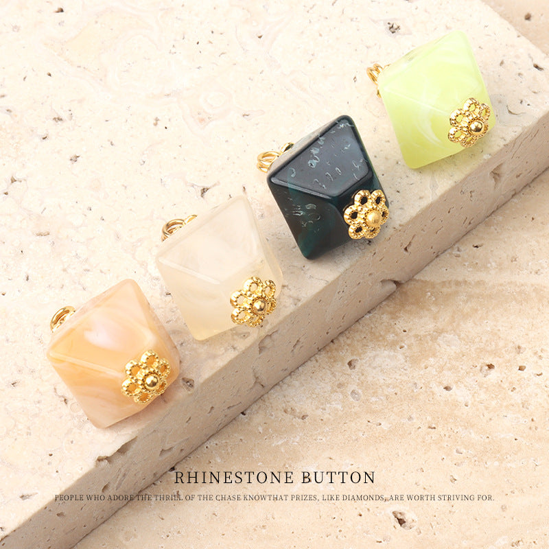 Multiple square translucent acrylic buttons with gold rhinestone flower centers in light green, peach, beige, teal.