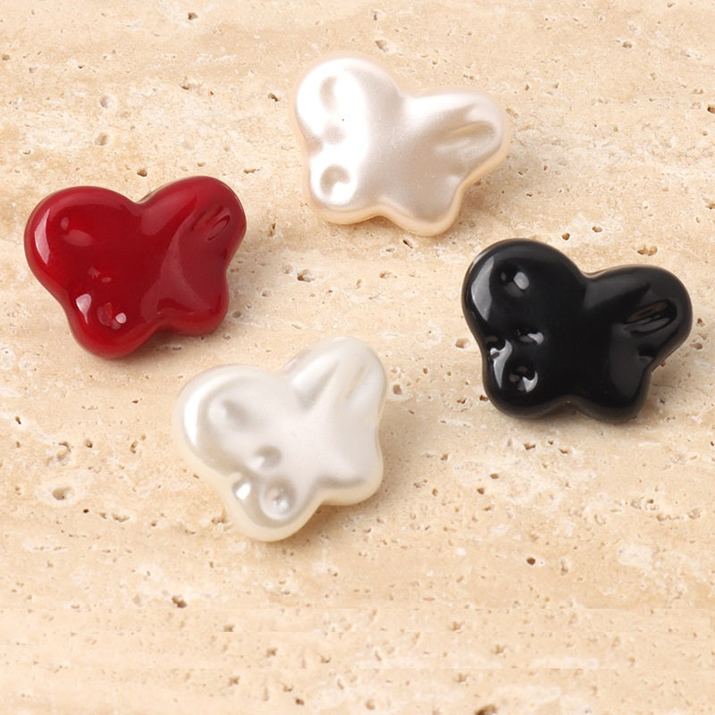 Resin butterfly sewing buttons in red, white, and black with metal shanks