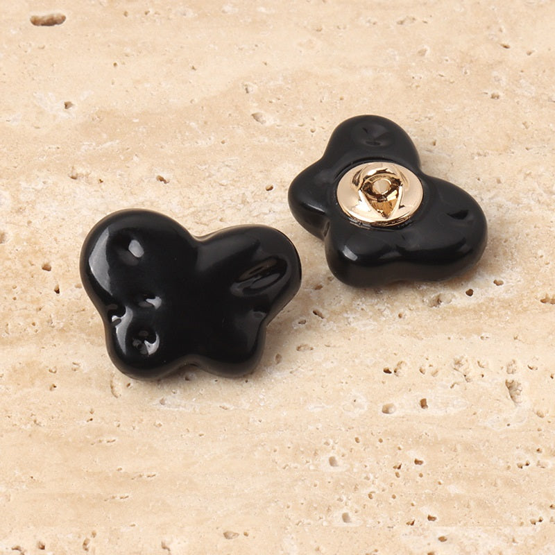 Black resin butterfly sewing buttons with metal shanks, two buttons shown