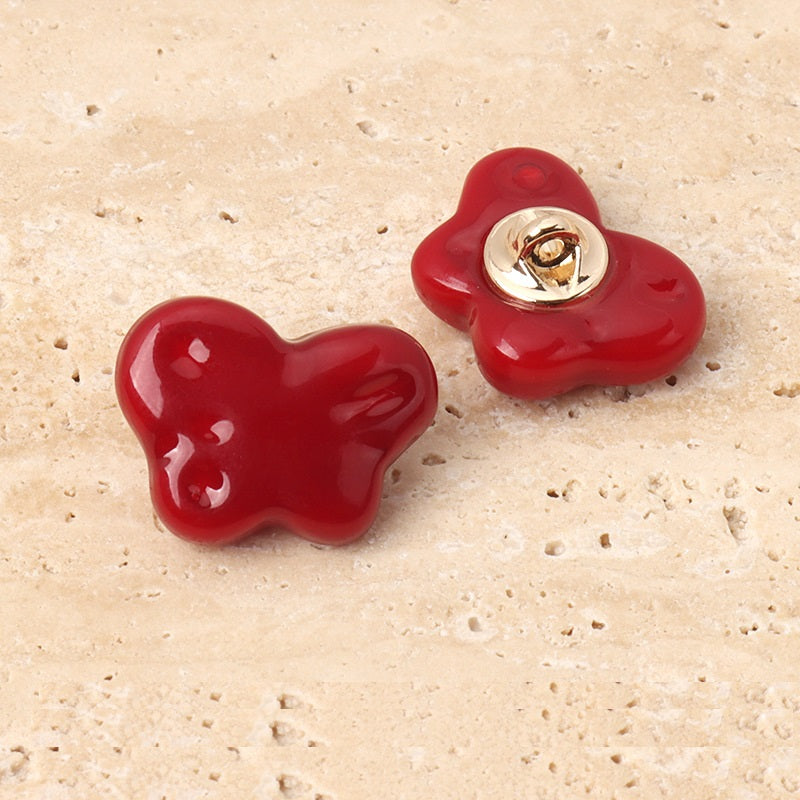 Red resin butterfly sewing buttons with metal shanks, two buttons shown