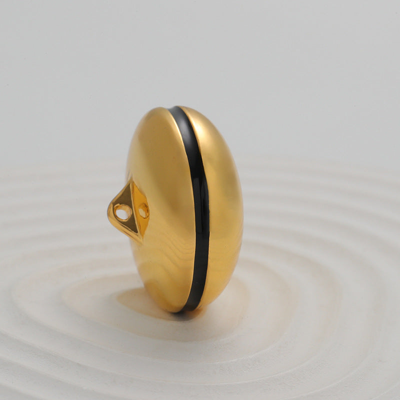 Gold spherical metal button with black side stripe and 2-hole attachment base