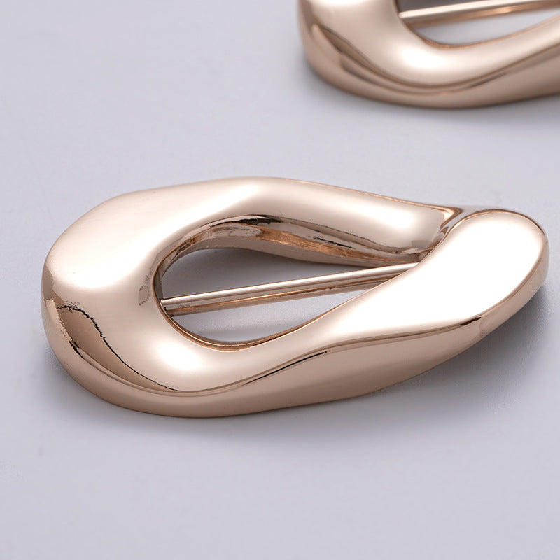 Close-up of irregular rose-gold buckle clasp with pin bar for fastening