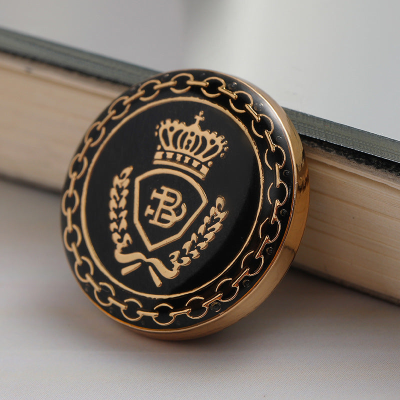 Vintage Metall-Jackenknopf, schwarz mit goldener Krone und Kettenmuster am Rand