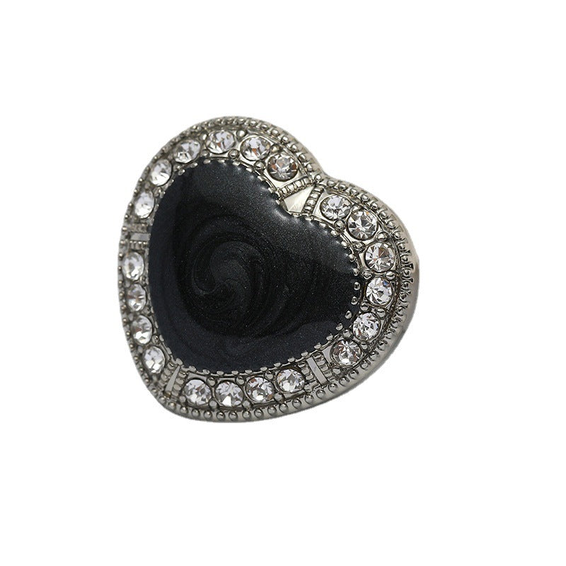 Heart-shaped black oiled metal button with rhinestone silver border and raised setting