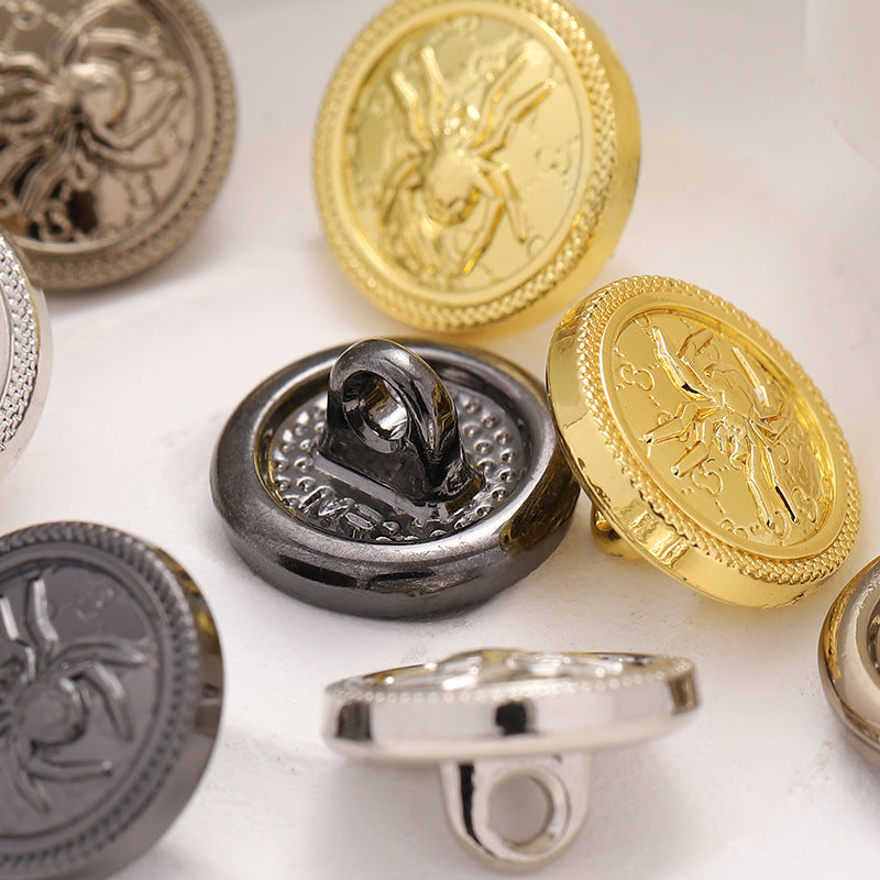 Close-up of round spider web pattern buttons, glossy high-foot backs in gold and dark silver