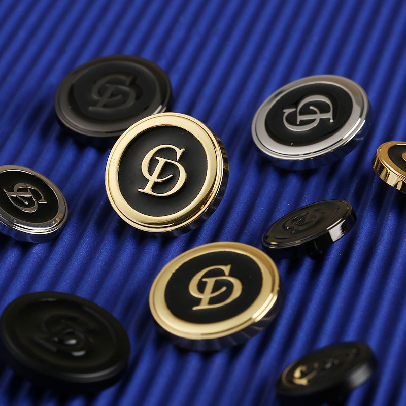 Assorted round CD clothing buttons with gold-tone and silver-tone rims, black centers