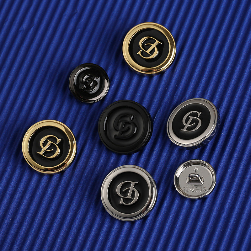 Set of round letter CD buttons in gold-tone and silver-tone with black centers