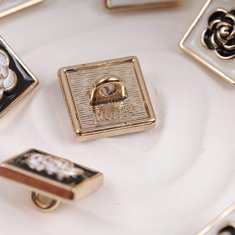 Back view of square metal button showing loop shank and attachment hardware