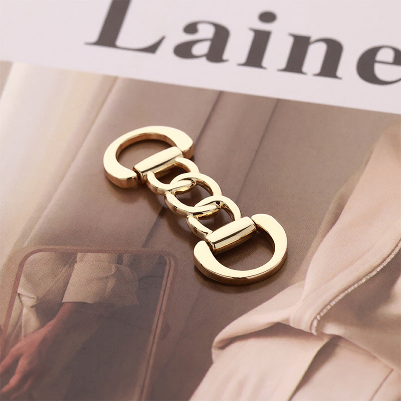 Gold metal chain-link belt buckle with oval clasp ends and hinged bar
