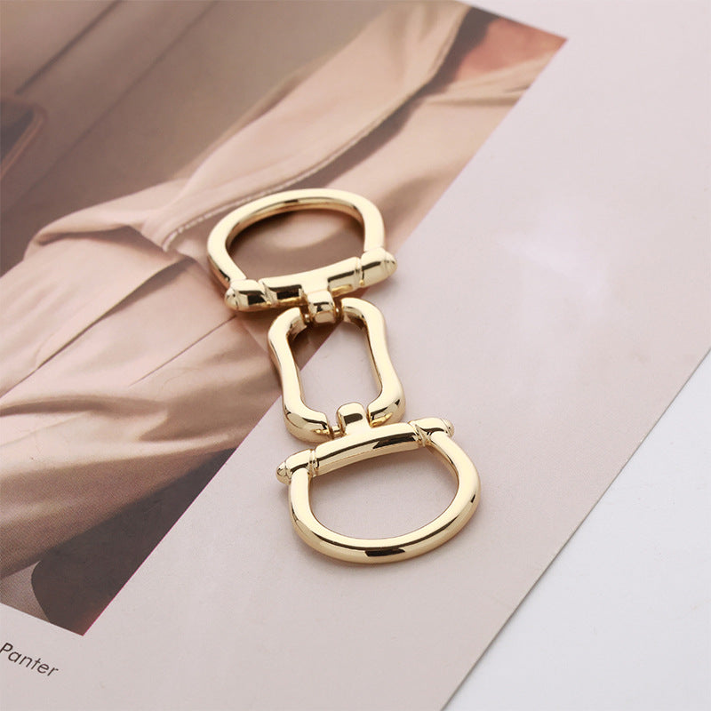 Gold chain-style belt buckle with two oval rings and central link details