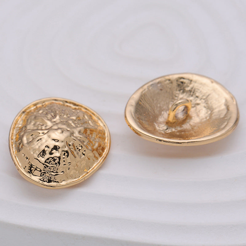 Rose gold clam-shell metal button with loop shank, underside view