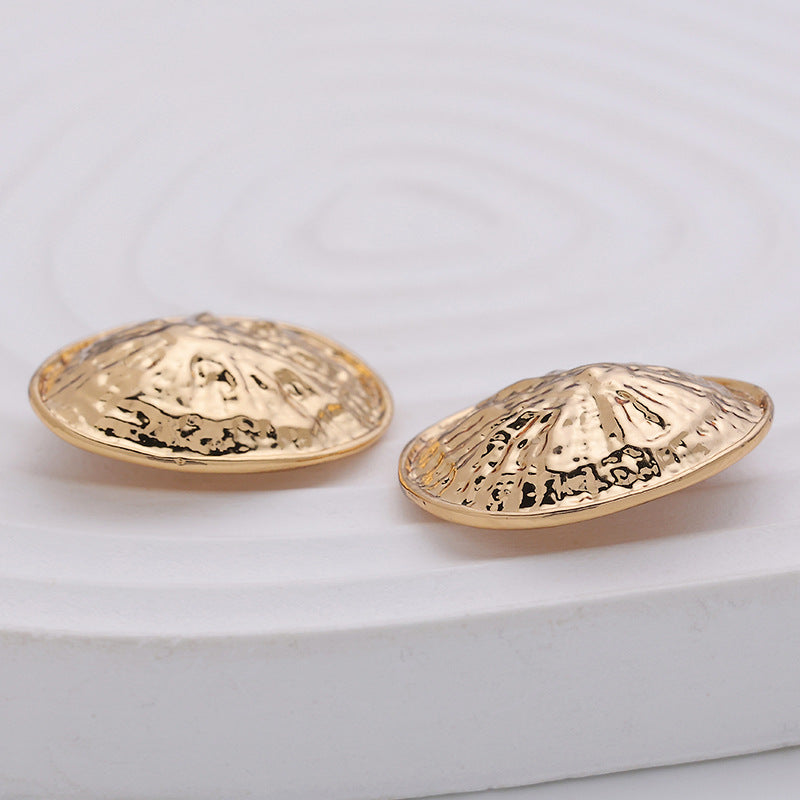 Side view of 22mm rose gold convex clam-shell metal buttons, hammered finish