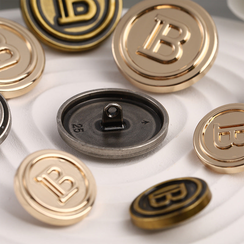 Round metal sewing buttons with letter B, back view with shanks, mixed finishes