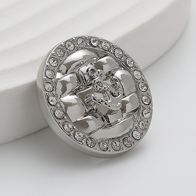 Silver metal button with rhinestone border and diamond anchor motif