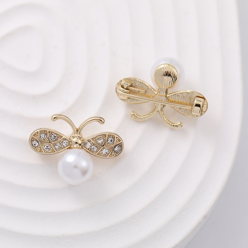 Bee-shaped pearl brooch with gold pin and clasp, white pearl and rhinestone wings