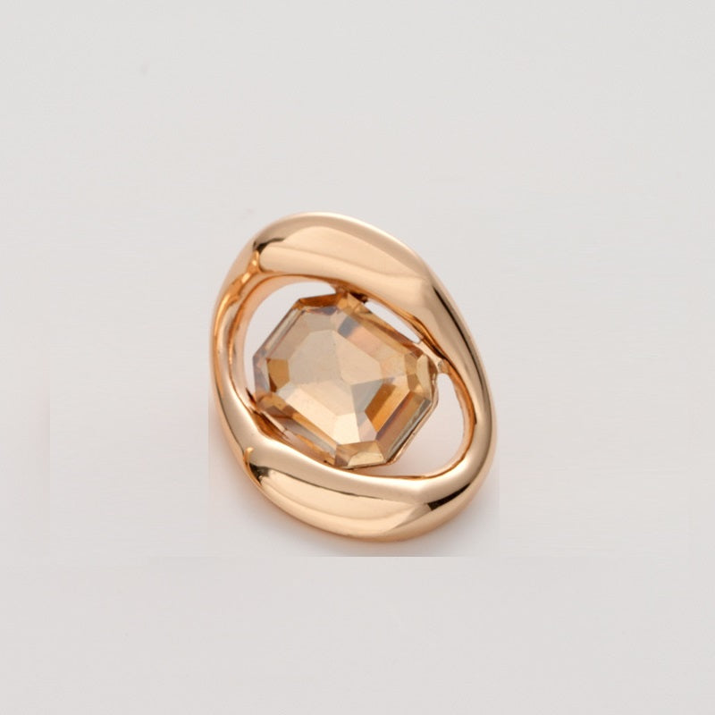 Gold-tone metal button with light orange faceted crystal in square geometric frame