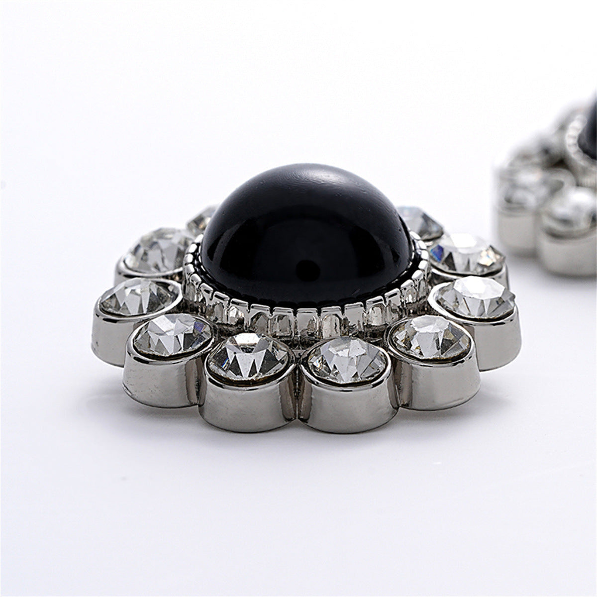 Cat’s eye pearl button with rhinestone border and pronged silver setting