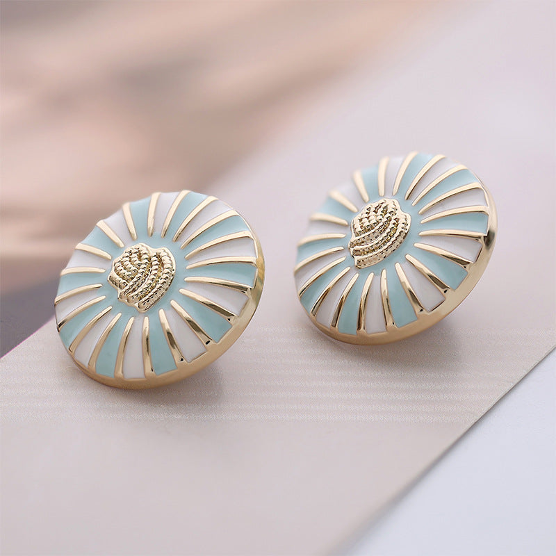 Pair of round buttons with sky blue enamel and white daisy spokes, goldtone edging