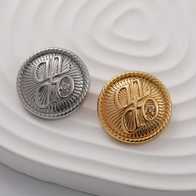 Silver and gold round metal buttons with ornate engraving and small crystal centers