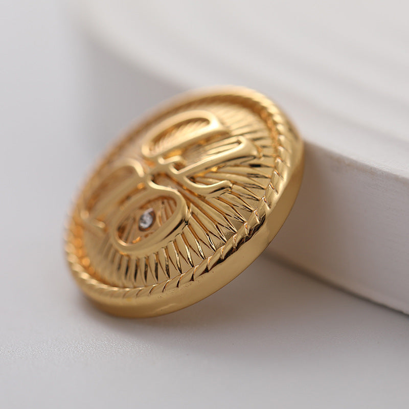 Gold round metal shirt button, ornate engraved petals and crystal center