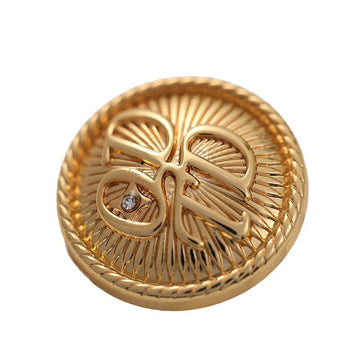 Gold round metal button with ornate flower-leaf engraving and crystal