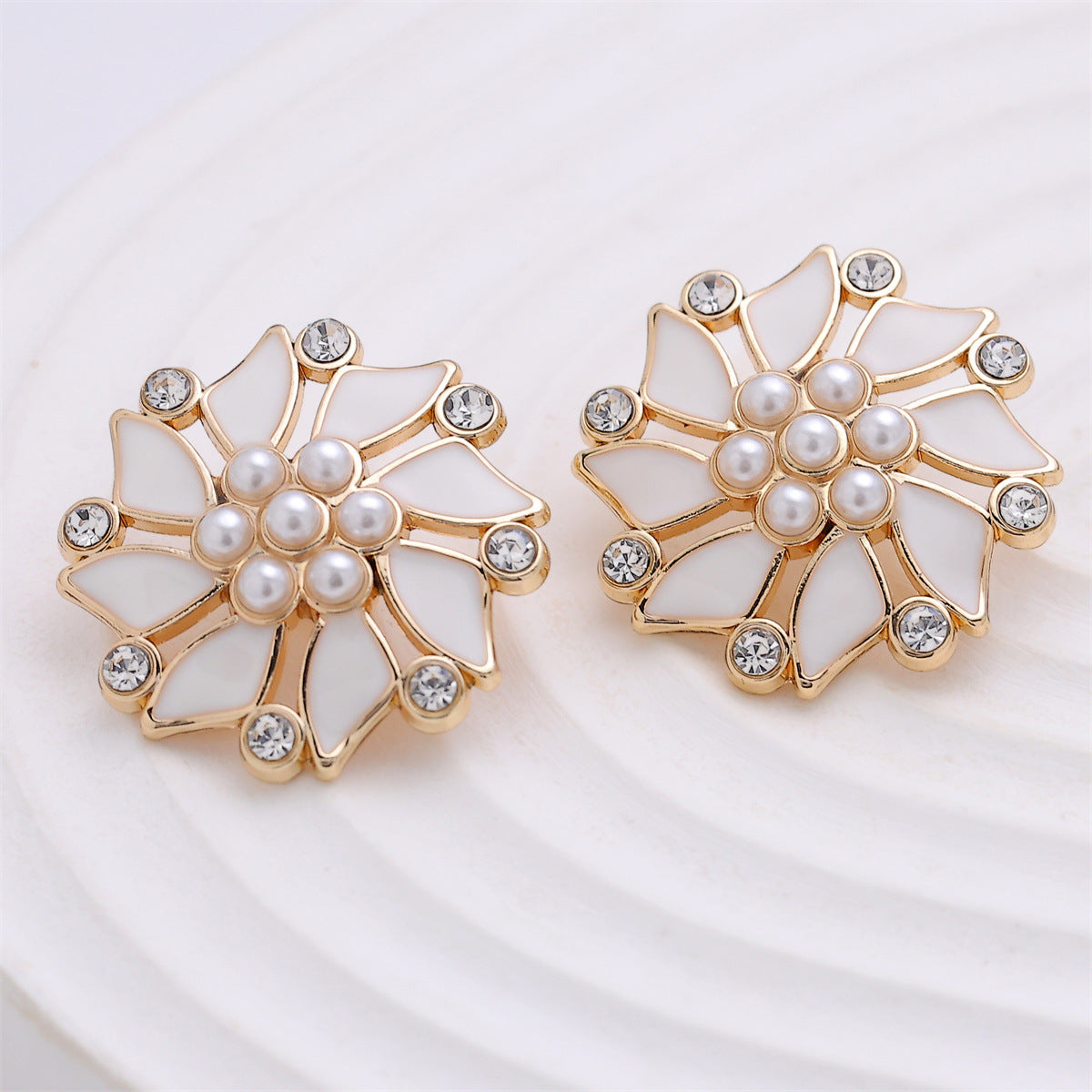 Two gold windmill coat buttons with white pearls and clear rhinestone accents