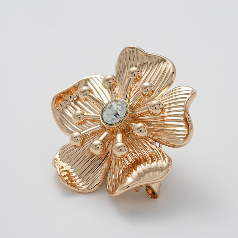 Gold flower rhinestone brooch, textured petal petals and central round crystal