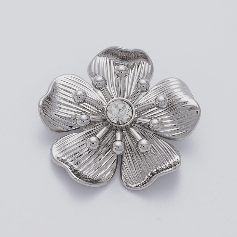 Silver flower rhinestone brooch with round crystal center and raised petal ridges