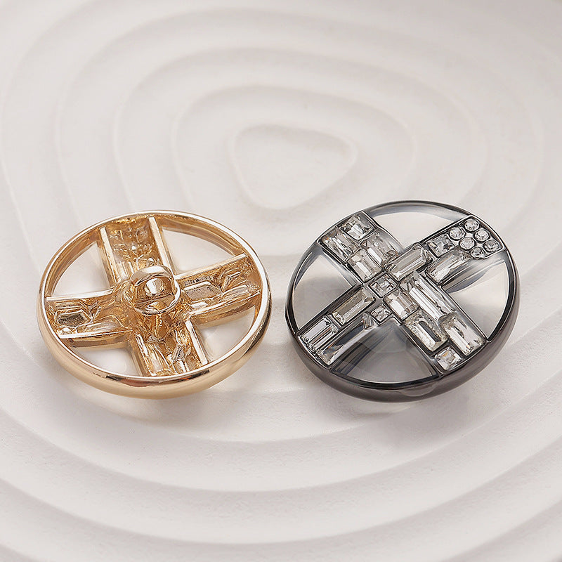 Round transparent diamond cross metal buttons, one gold and one silver tone