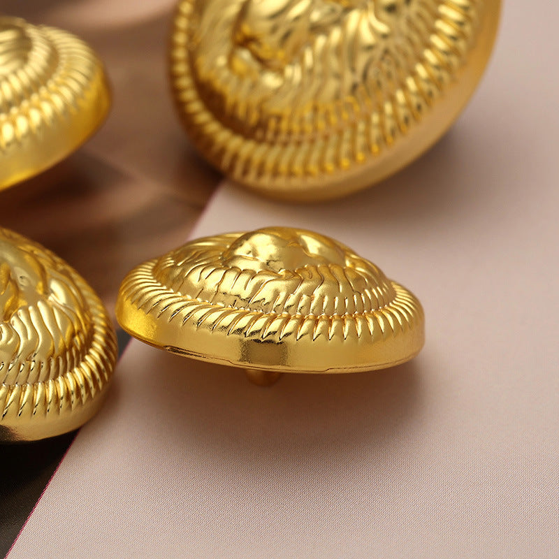 Lion head metal button, gold tone with serrated edge, side view
