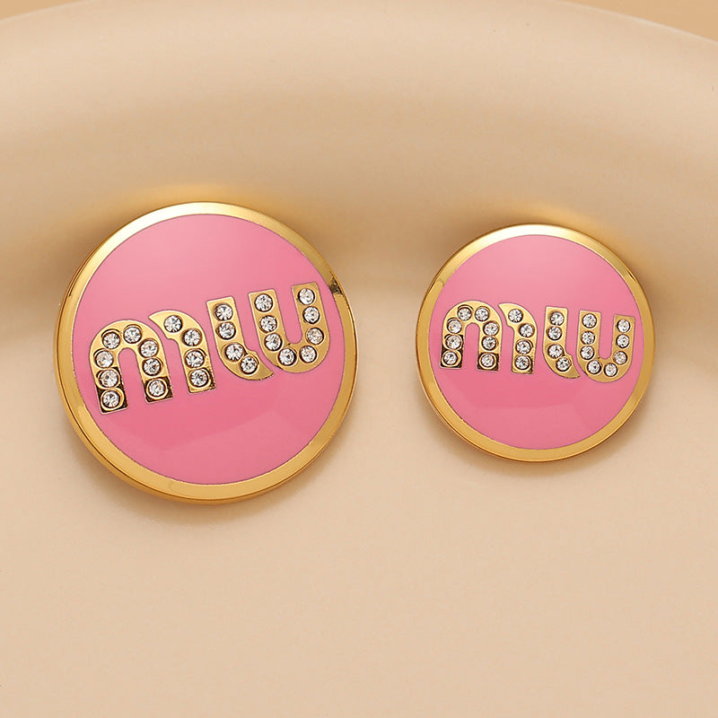 Round metal sewing button, pink lacquer MIU letters with rhinestones, gold rim