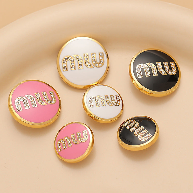 Set of round metal sewing buttons with MIU letters in white, black, and pink lacquer