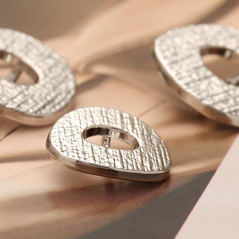 Textured oval metal coat button with central loop and high-stem shank, hemp pattern