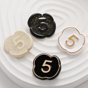 Number 5 lacquer button, black with gold “5” and pearl speckle floral edge.