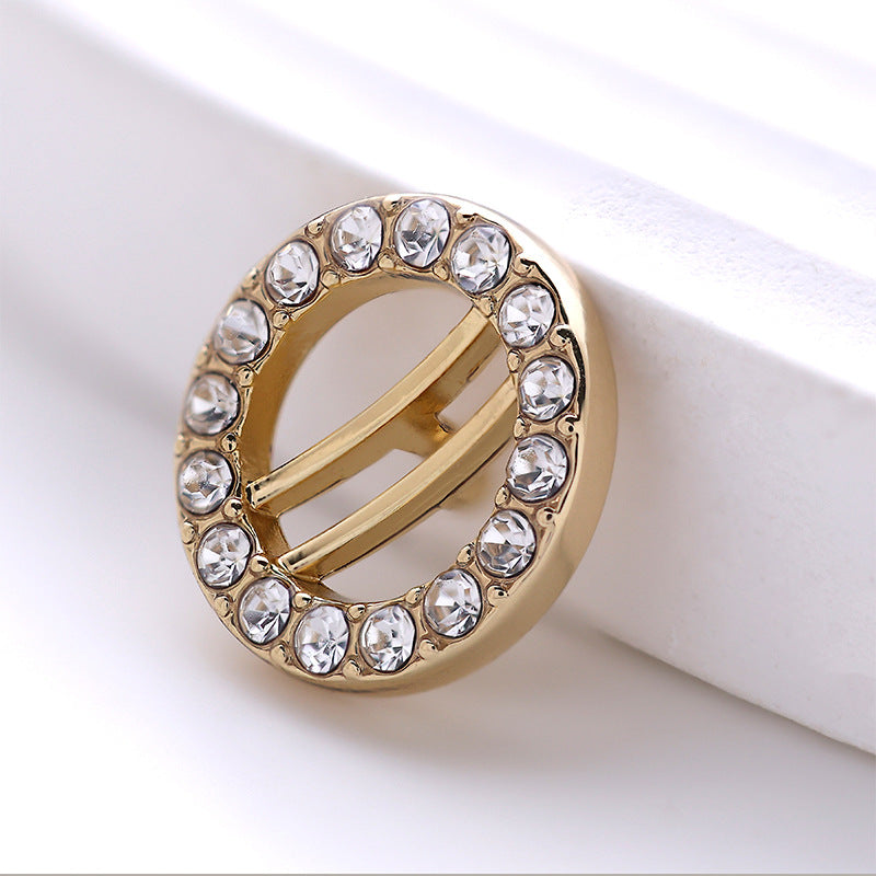 Runder goldener Knopf mit Diamant-Ziersteinen im Kreis, Mittelsteg sichtbar