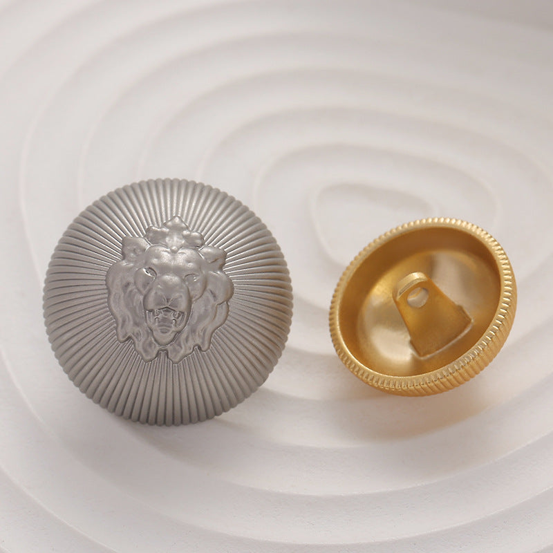 Silver lion head button with gold-toned back and looped shank handle