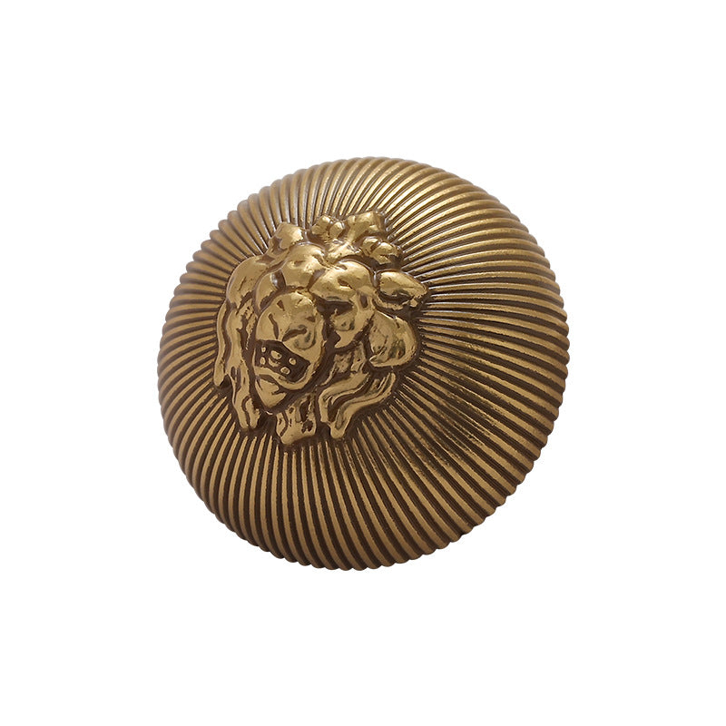 Gold lion head metal button with ribbed circular design and raised handle
