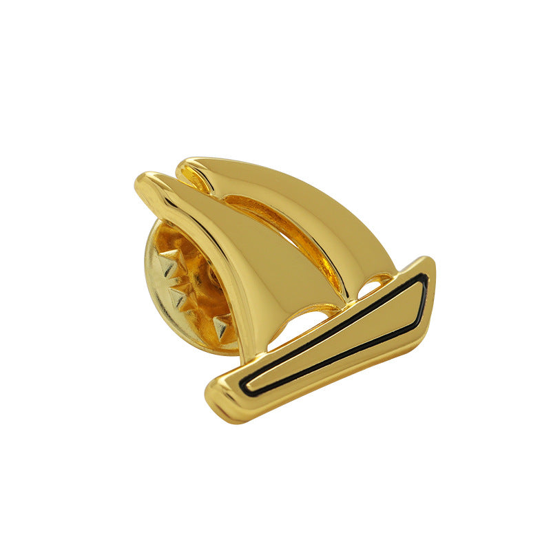 Gold boat-shaped metal brooch pin with curved sail design