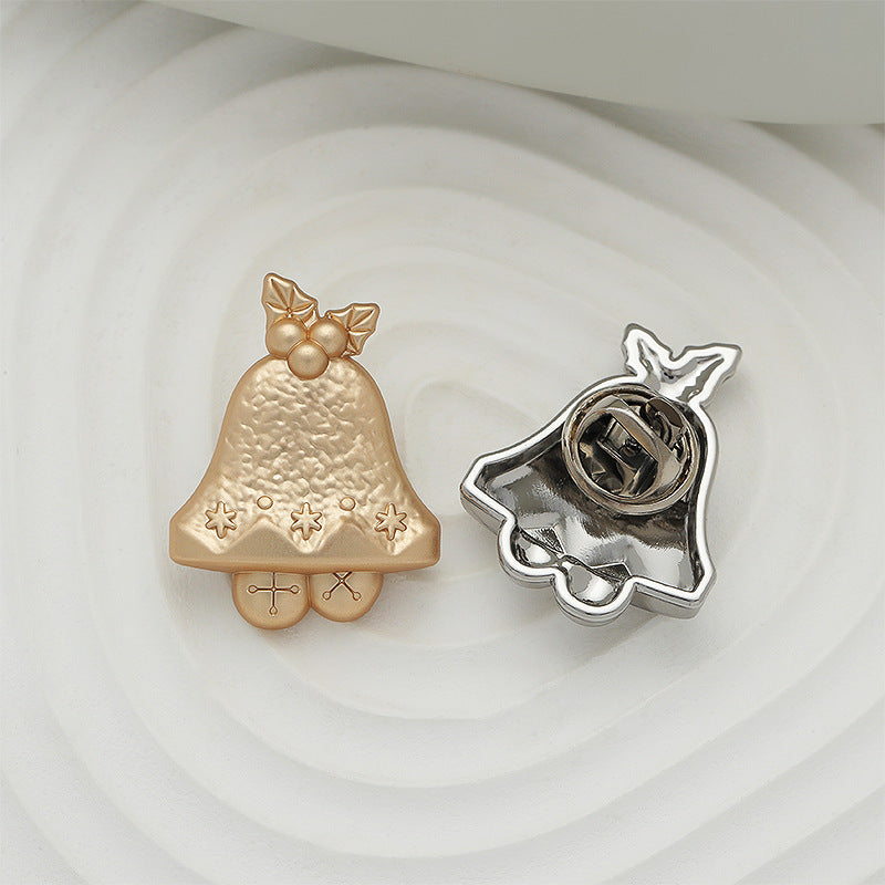 Gold Christmas bell brooch front with bow and stars, plus silver-tone pin backing