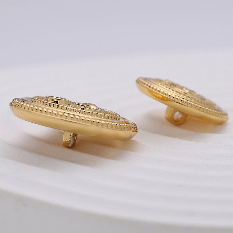 Goldfarbener Zierknopf, runde Vorderseite und flacher Nietenstift von der Seite