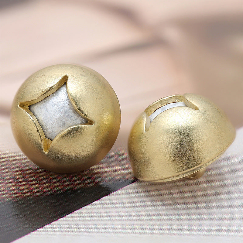 Gold mushroom-shaped metal decorative button with star inset, angled front view