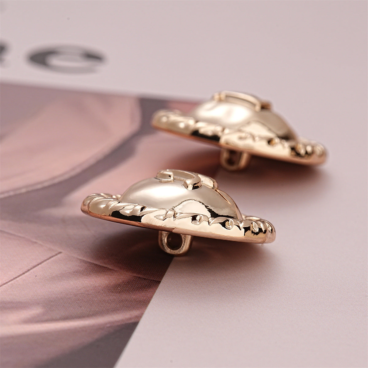 Light gold metal sewing buttons, side view of shank posts with letter A centers