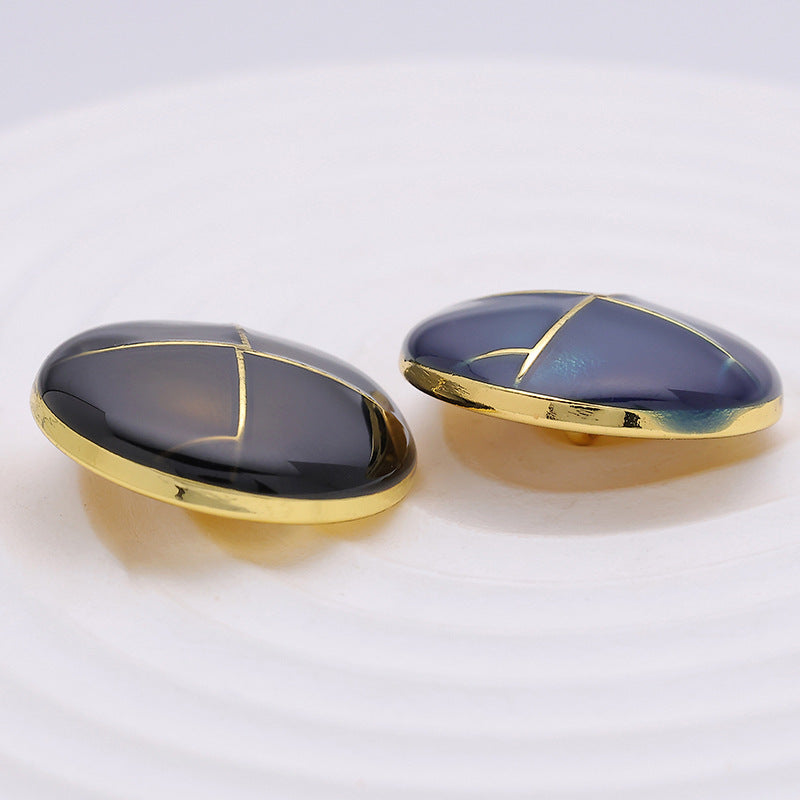 Side view of blue and black 23mm crosshatch metal buttons with gold edges