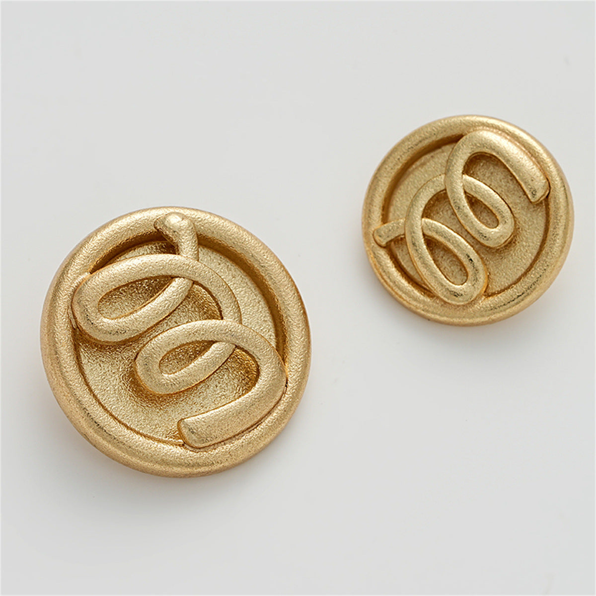 Set of two sand-gold M relief hollow metal buttons, circular 3D lettering