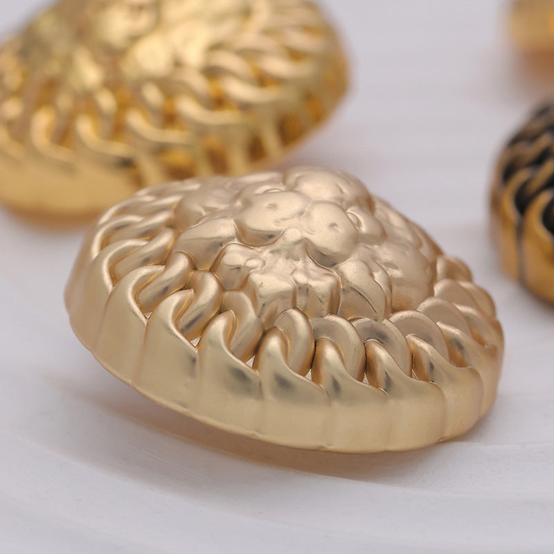 Round metal button underside with raised lion-maned detail, gold-tone