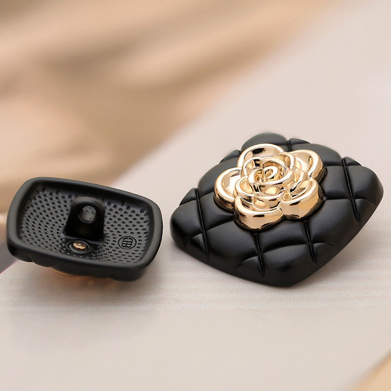 Black square metal button back view with gold camellia, snap posts visible