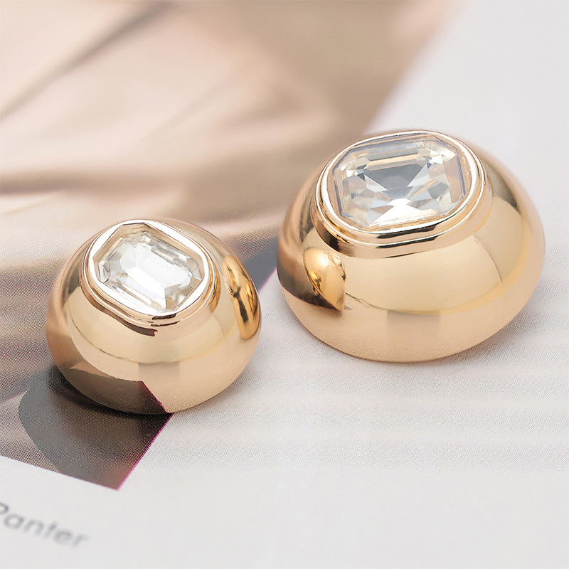 Pair of convex metal buttons, gold finish with clear faceted diamond tops
