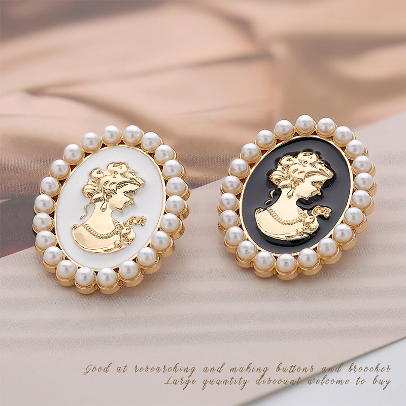 Two pearl brooch pins: white and black oval cameos with gold beauty portrait, gold frames