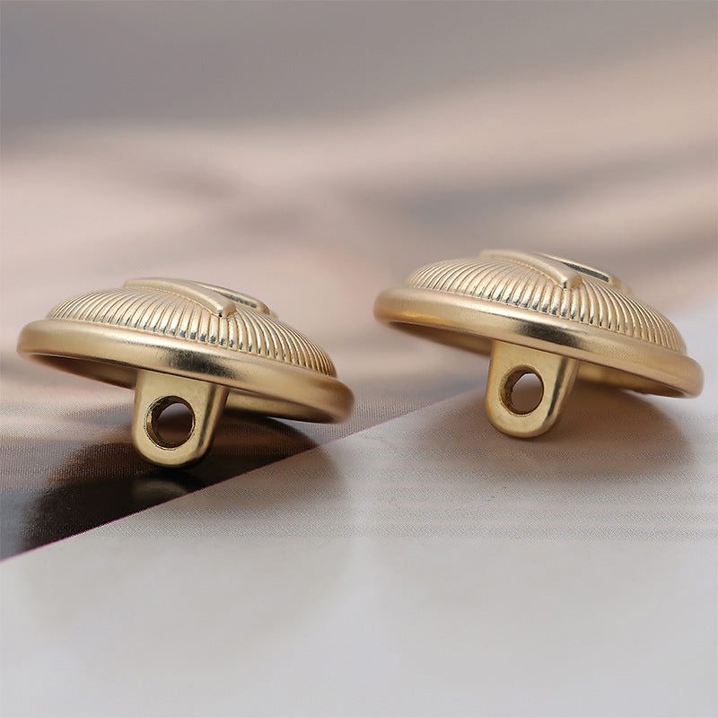 Light gold metal sewing buttons underside view, two loop posts, ridged edge