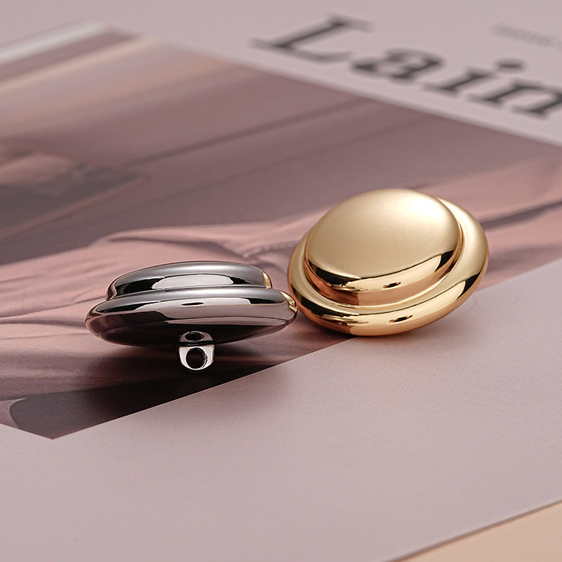 Round metal buttons in silver and gold with hollow-back design